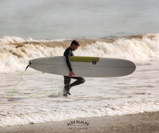 surfer carrying his surf board